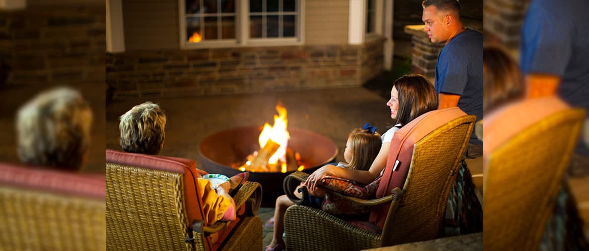 One Round Wood Fire Pit in Front of Family at Night